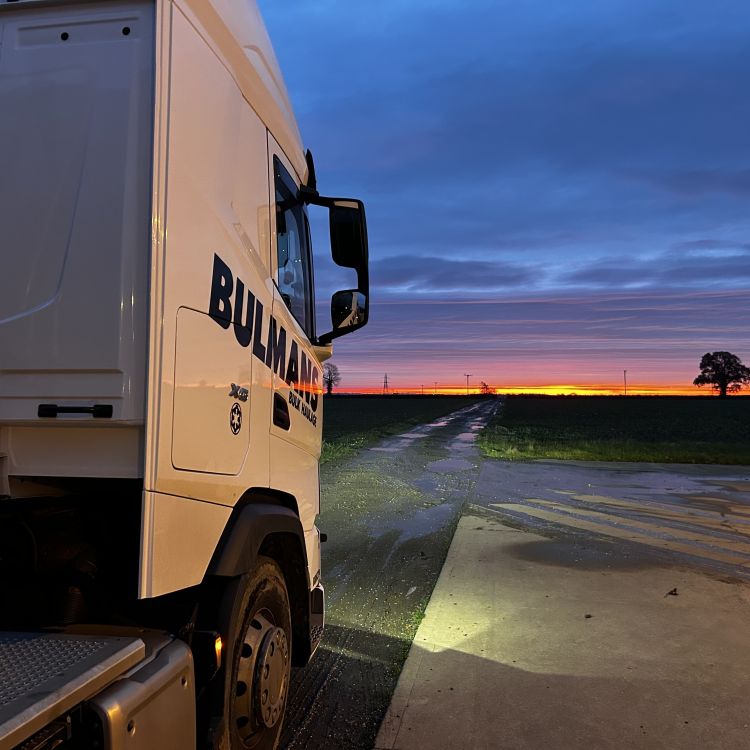 Rear side view of a Bulmans Bulk DAF truck cab, facing towards the horizon at sunset.